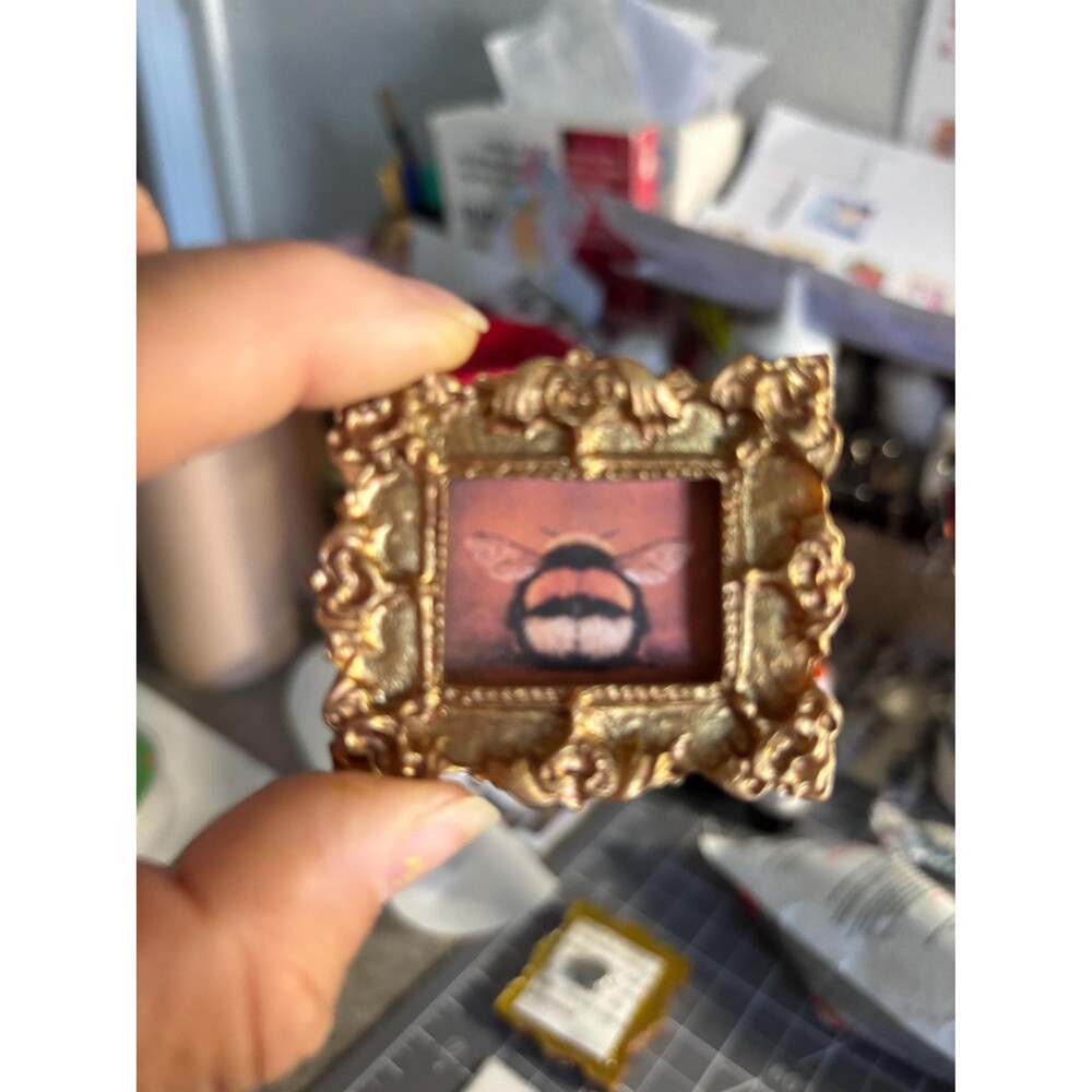 Adorable bumblebee in a gold framed magnet.